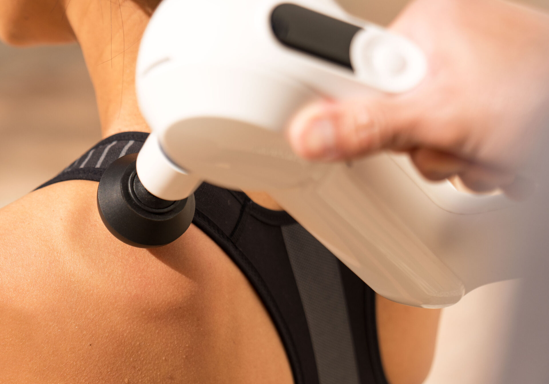 Therapist Treating Patient's Trapezius Muscle with Massage Gun Stock Photo  by microgen